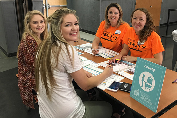 Students smiling and participating in financial reality fair