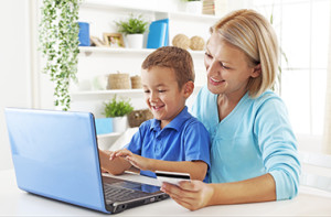Mother and son sitting by laptop