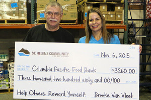 portrait of food bank director and st. helens community ceo presenting check