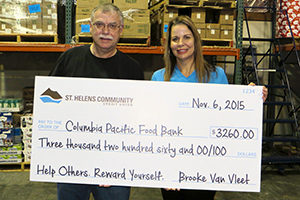 CEO Brooke Van Vleet presenting donation check to Casey at Columbia Pacific Food Bank
