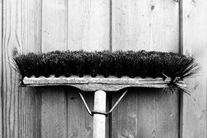 broom hanging on wooden wall