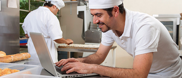 Chef on laptop in kitchen