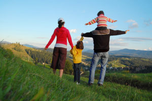 Family outside on a grassy hill enjoying the outdoors