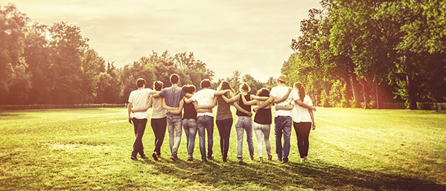 group of young adults walking together with arms around one another