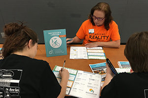 female employee talks to two high school students