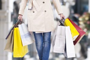 young woman walking with shopping bags in hands, christmas background