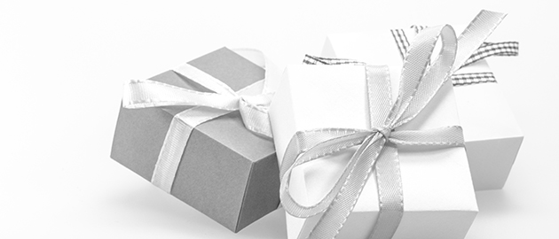 white background with white and gray wrapped gifts, tied with silver bows