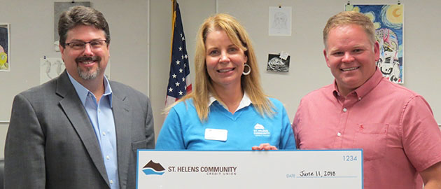 Scappoose Superintendent Paul Petersen, St. Helens Community CEO Brooke Van Vleet, and Scappoose School Board Chair Phil Lager hold large novelty check