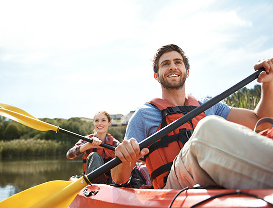 Shot of a young couple kayaking together on a lake