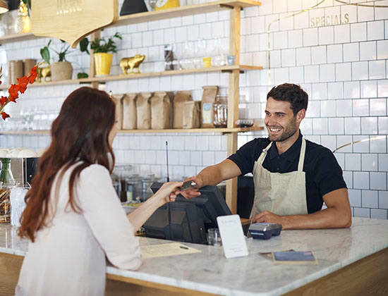 Cropped shot of a male barista helping a customer in a coffee shop