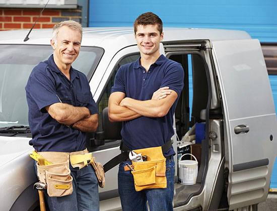 Workers In Family Business Standing Next To Van