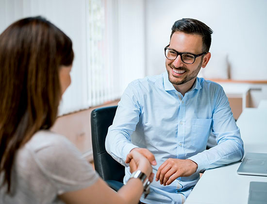 Businessman and businesswoman shaking hands in office