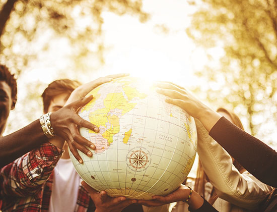 diverse group of hands holding a globe