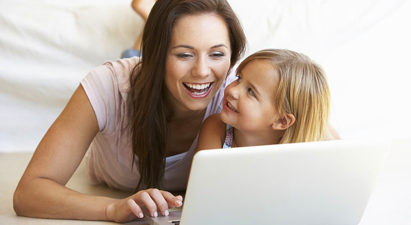 Young woman with girl using laptop computer