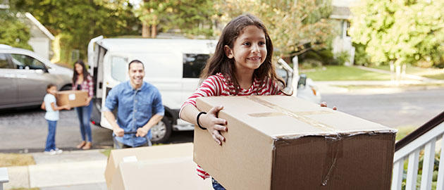 Children Helping Unload Boxes From Van On Family Moving In Day