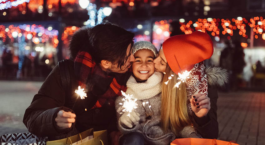 holiday shopping family kissing sparklers