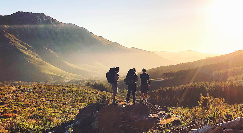 hikers in summer climbing mountain sunset