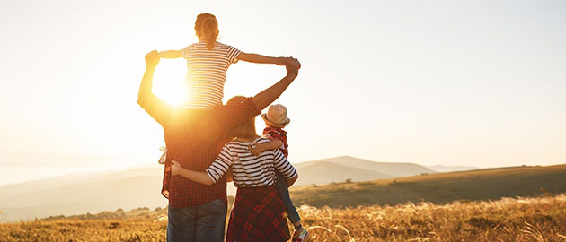 Happy family: mother, father, children son and daughter on nature on sunset