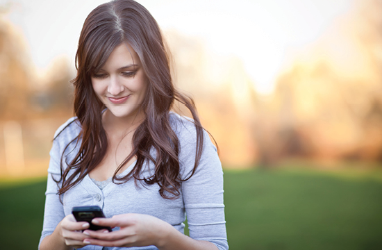 woman holding cell phone and smiling