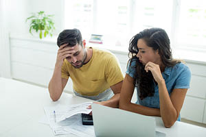 man woman kitchen concerned computer taxes
