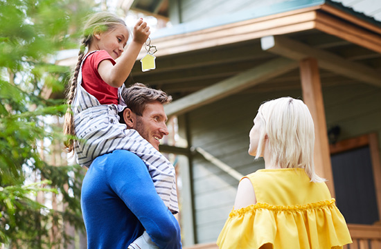 young family with keys to their home, dad has daughter on his shoulder