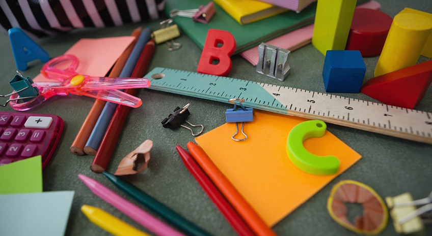 Various school supplies on chalkboard