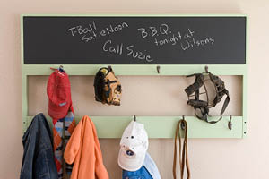 repurposed headboard with hooks into an organizer for a hallway with a chalkboard