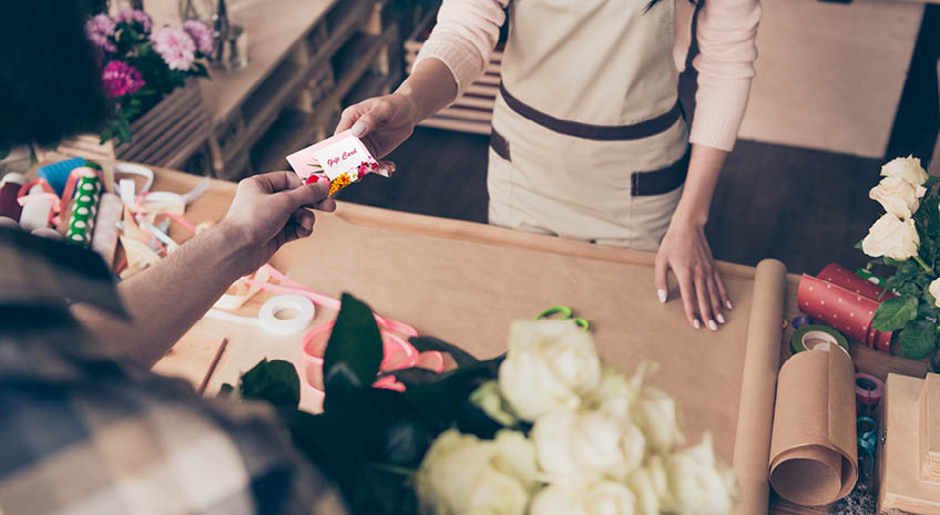 man purchasing white roses with a gift card