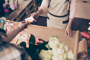 man purchasing white roses with a gift card