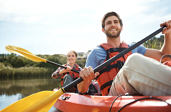 Shot of a young couple kayaking together on a lake