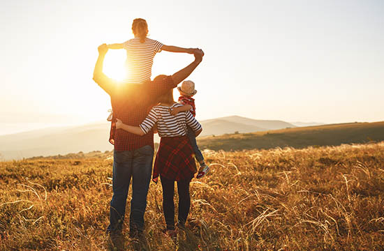 Happy family: mother, father, children son and daughter on nature on sunset