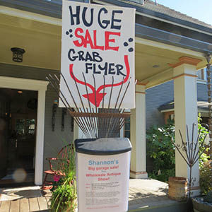 flier box with garage sale info, balancing on an old rake