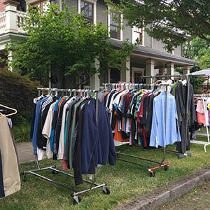 clothing racks of clothes at a yard sale