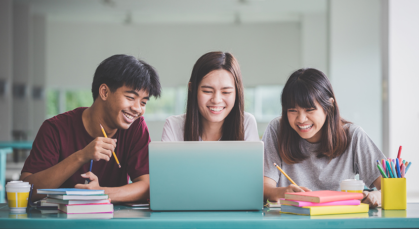 Group of friend or students smile happily with laptop on table on campus.