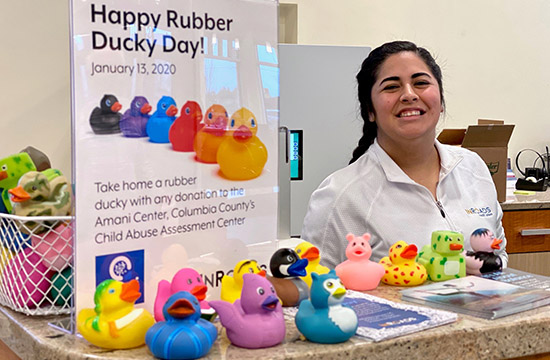 female employee standing behind counter with lots of rubber ducks in front of her