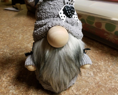 handmade gnome with grey beard and hat. made by employee aimee thompson.