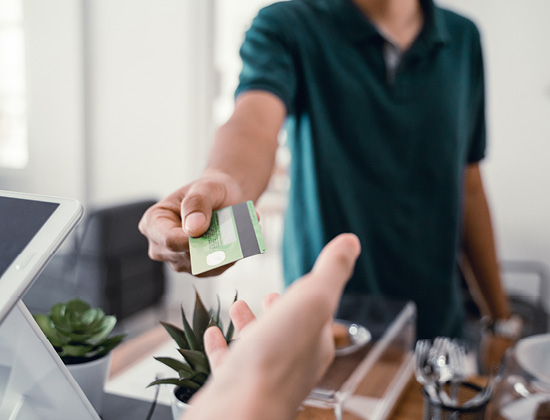 male customers pay their purchases to the cashier using a credit card