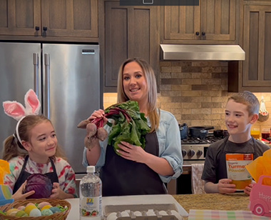 emma, alexandria, and joe pose with produce to make natural dyed eggs