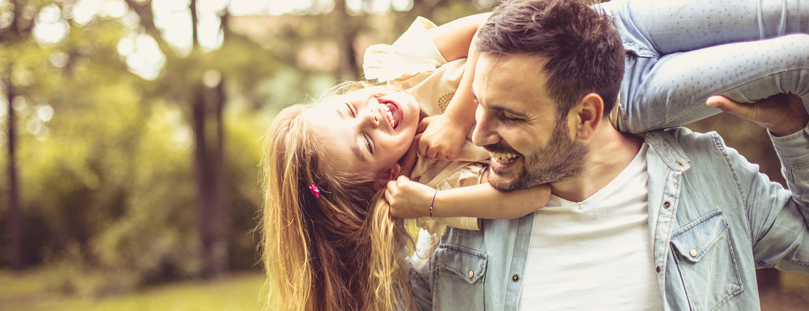 Happy smiling father and daughter spending summer day at park.
