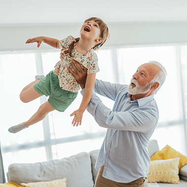 Image of senior man - grandfather and his granddaughter having fun at home