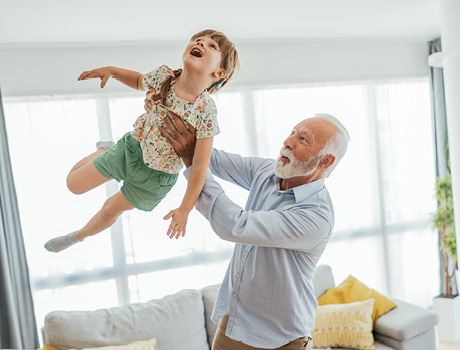 Image of senior man - grandfather and his granddaughter having fun at home