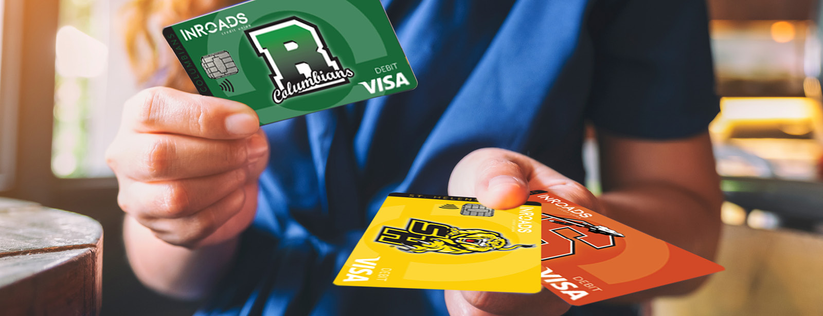woman in blue holding 3 inroads team up for schools debit cards