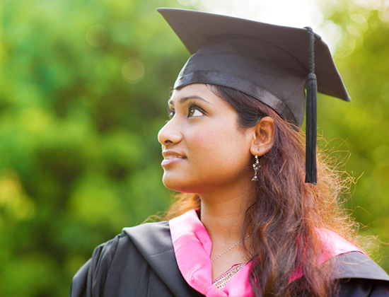 indian girl in a cap and gown on graduation day