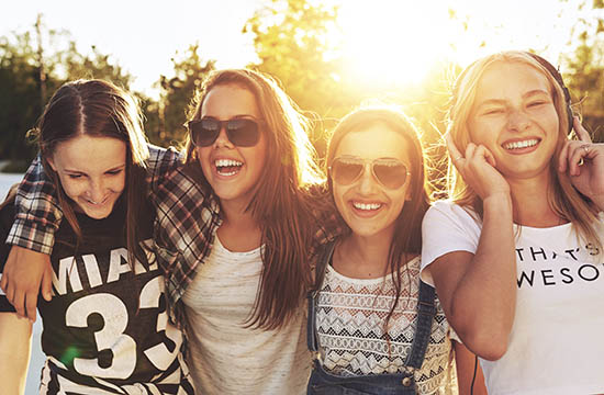 Teenage girls laughing and walking on a line