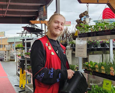 male employee outside watering plants