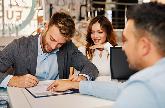 Young couple signing a pro forma invoice to buy new things for the interior of the home